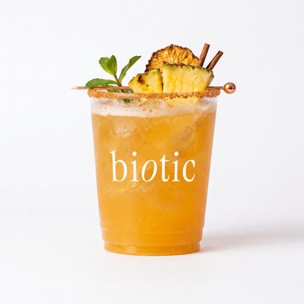 Golden biotic cup with a pineapple and cinnamon garnish on white