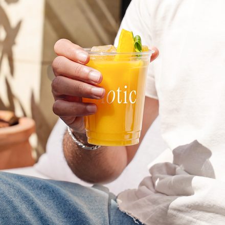 Hand holding a golden biotic cup in soft daylight
