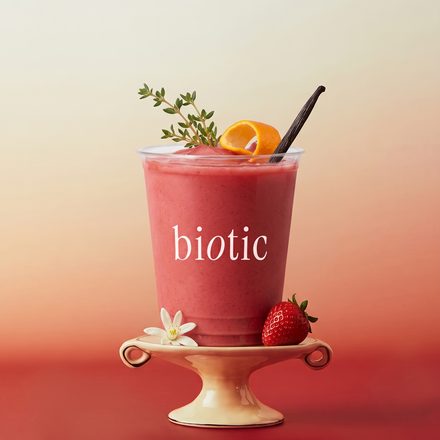 Pink drink on a pedestal with strawberries and citrus