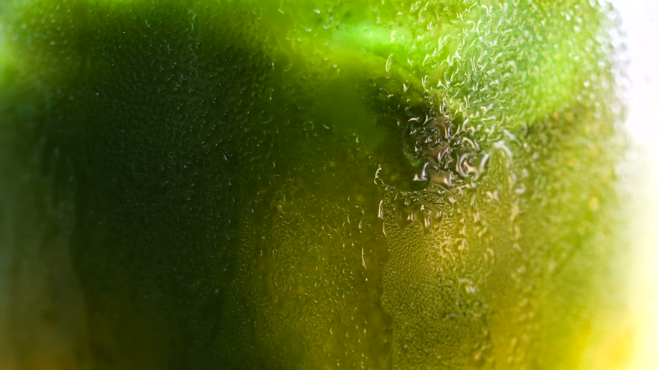 Close-up of iced matcha behind a frosted, condensation-covered glass